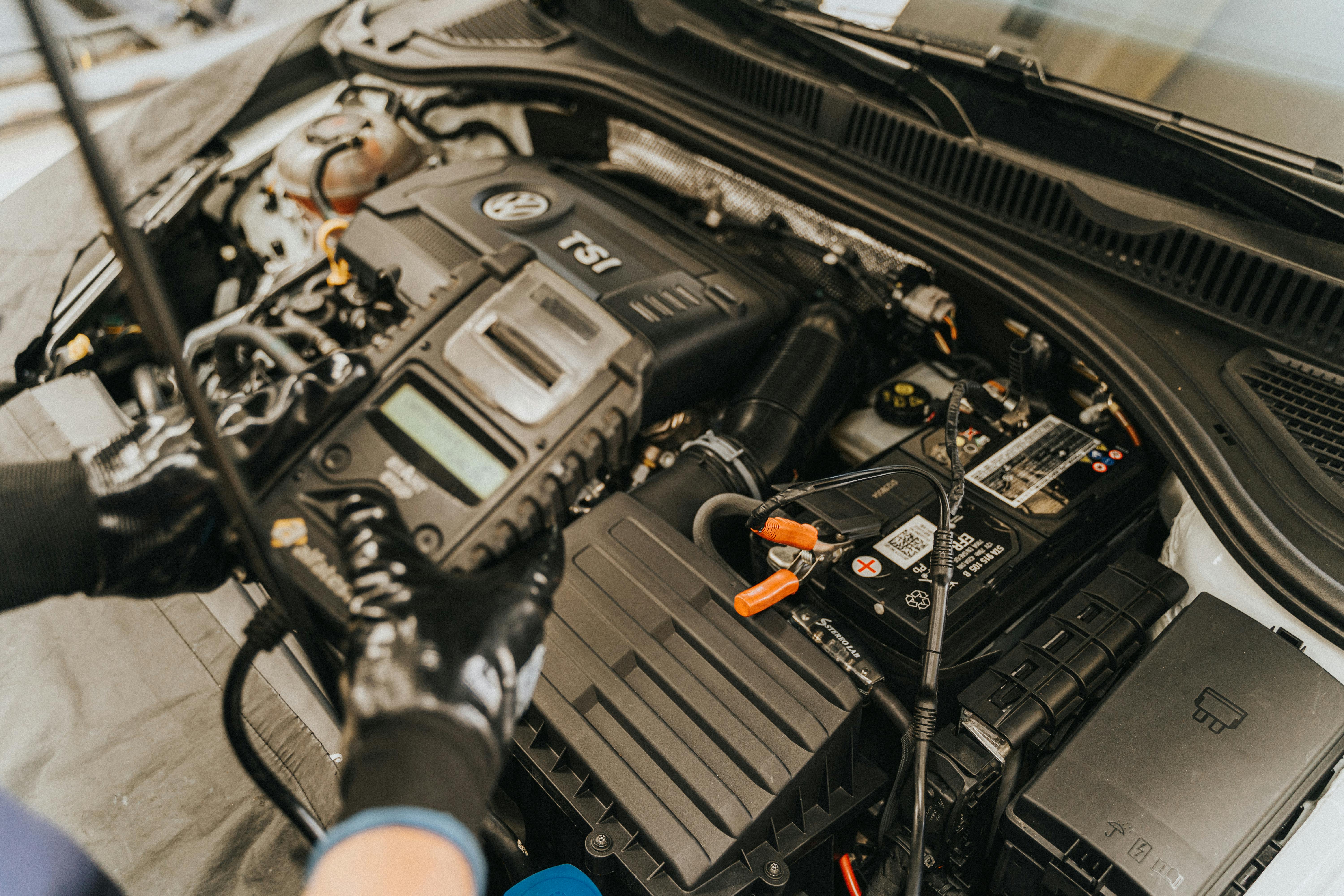 A mechanic working on a car battery